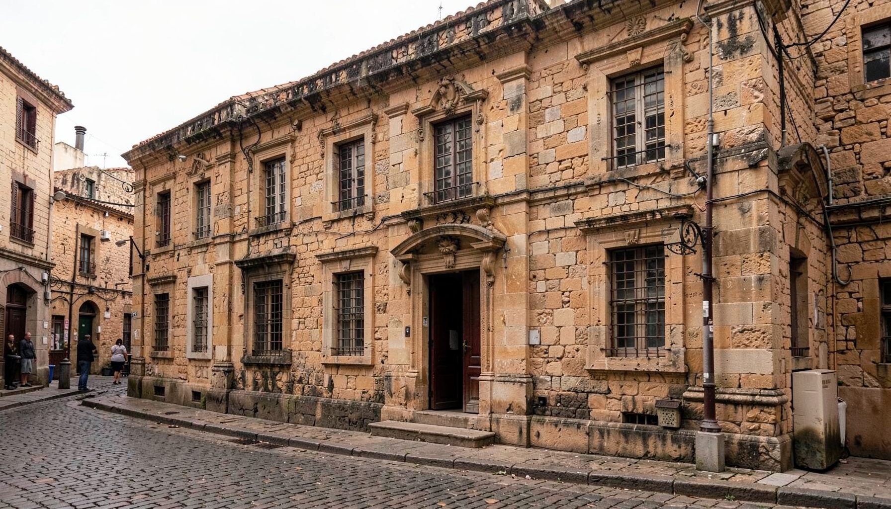 Old stone colonial building facade in warm earthy tones with a quiet cobblestone street, muted historical atmosphere